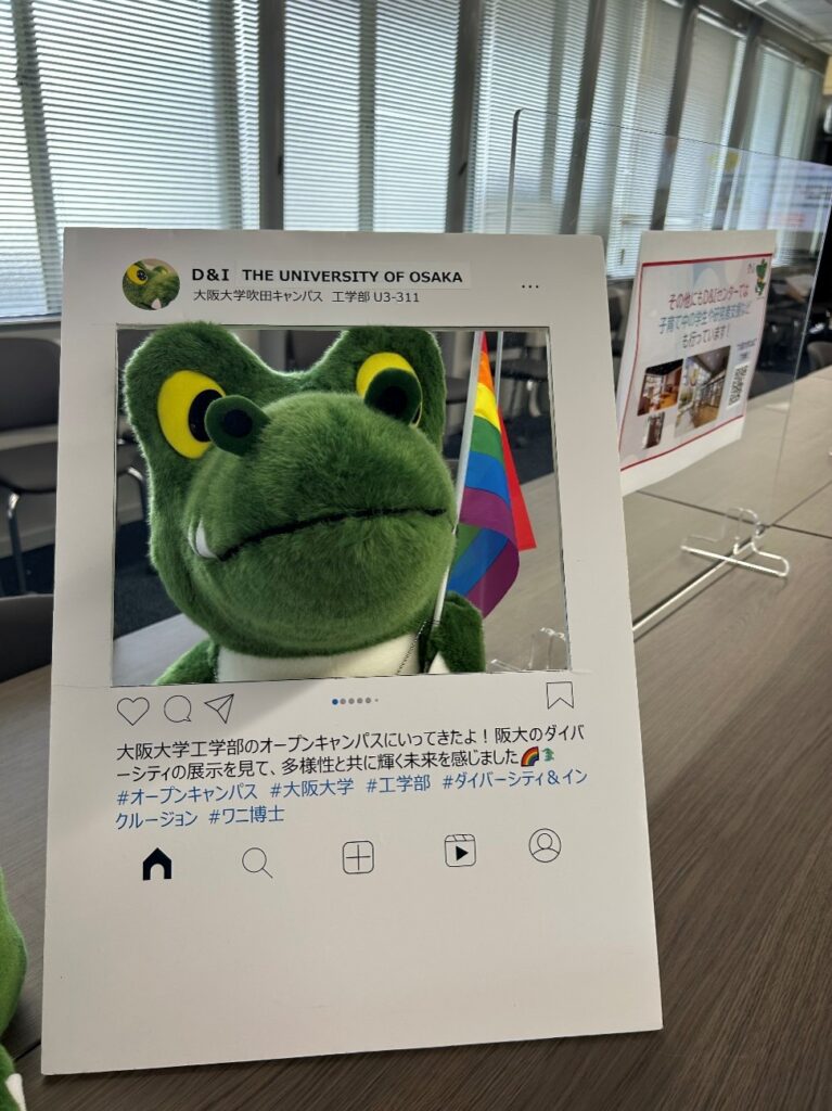 写真撮影用に用意したインスタグラムの投稿風の顔出しパネルと、レインボーフラッグをもったワニ博士の様子